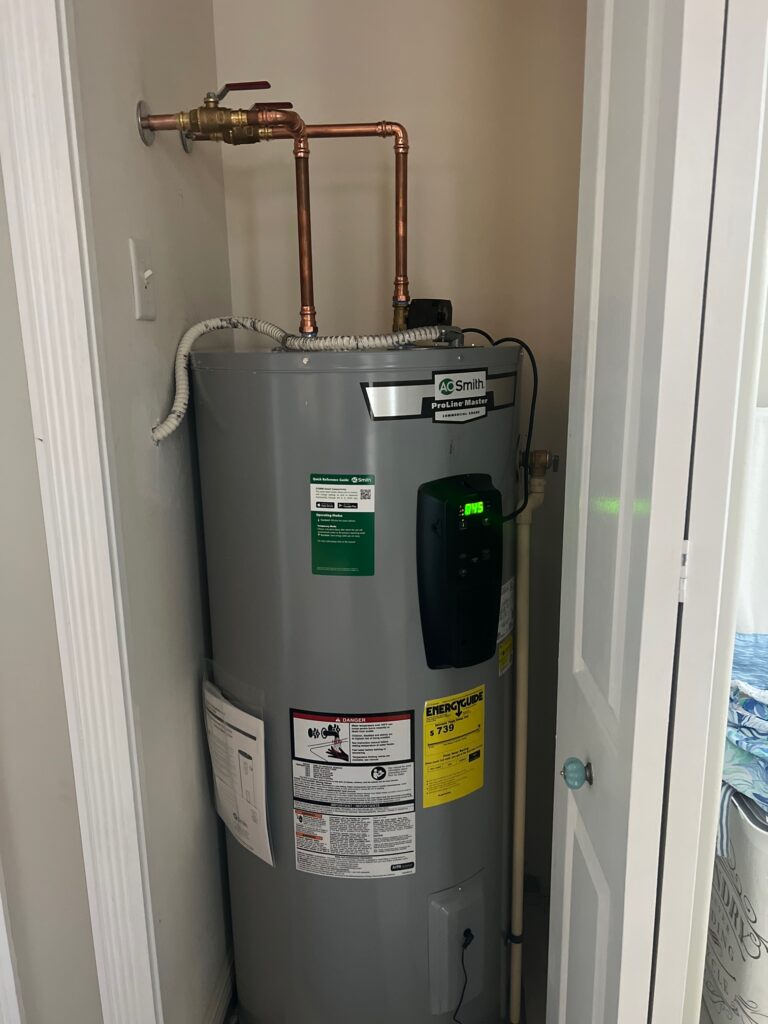 Tank water heater installation with connected plumbing.